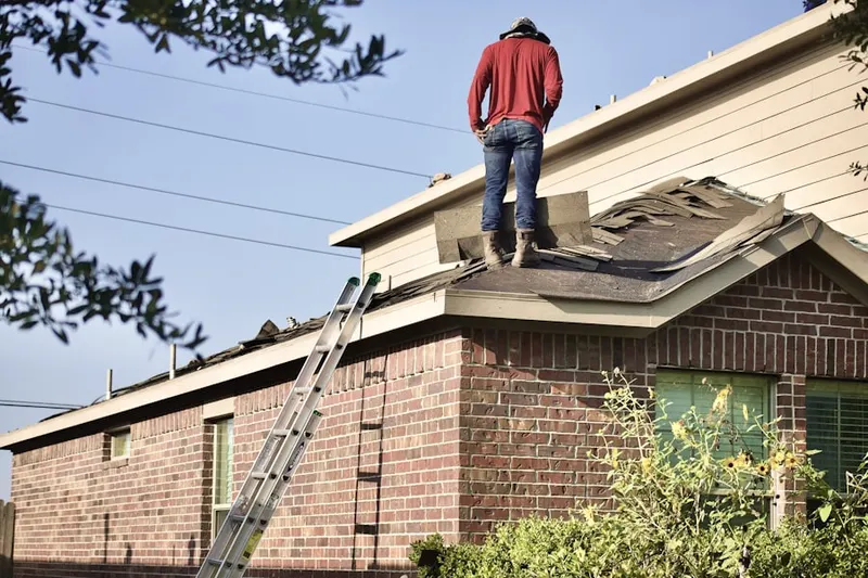 Professional roofer working on a residential roof in Bruceville